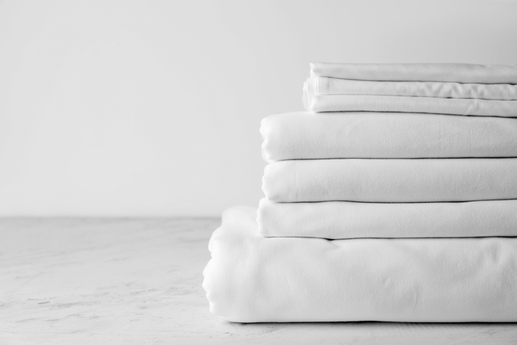 Freshly folded sheets and pillowcases for short-term rental properties